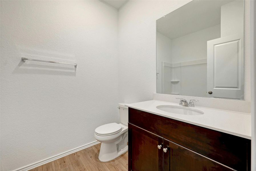 Bathroom with vanity, light wood-style flooring, and a textured wall