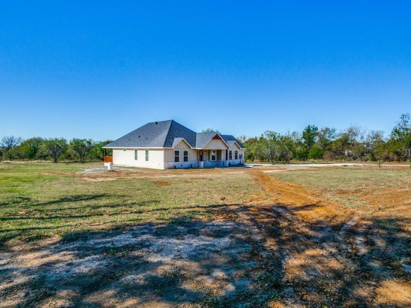 View of front of house featuring a rural view and a front yard