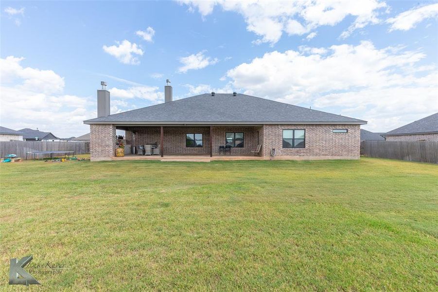 Back of property with a fenced backyard, brick siding, and a patio Back of property with a fenced backyard, brick siding, and a patio