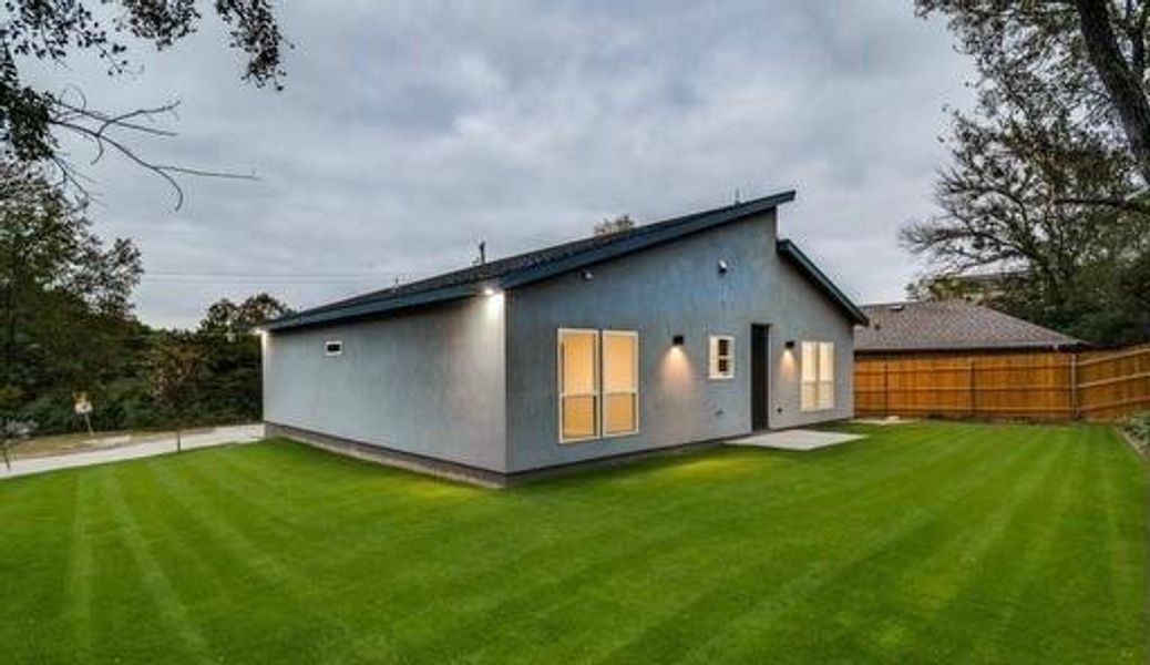 Rear view of house featuring a lawn