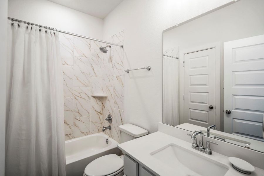 En-suite bathroom continuing the modern design and sleek tile work.