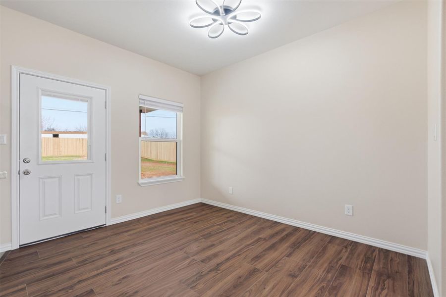 Foyer entrance with dark wood-style floors and baseboards