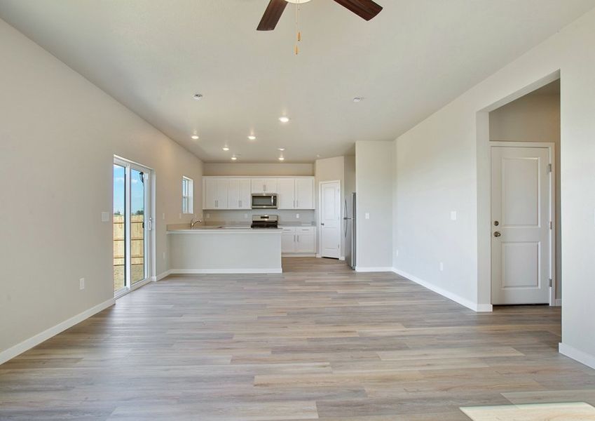 The family room is spacious with plank flooring and a ceiling fan.