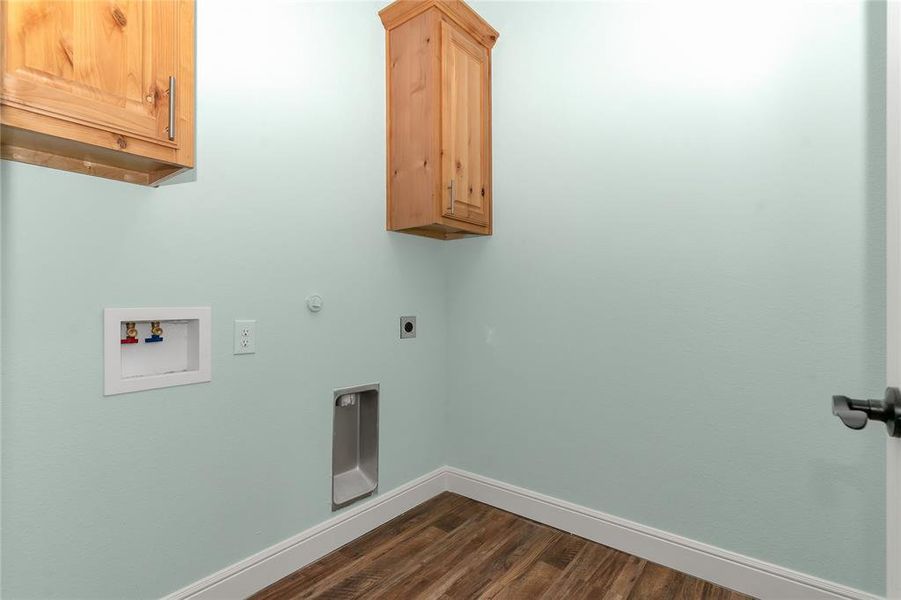 Laundry area featuring dark wood-type flooring, hookup for a gas dryer, cabinet space, electric dryer hookup, and hookup for a washing machine