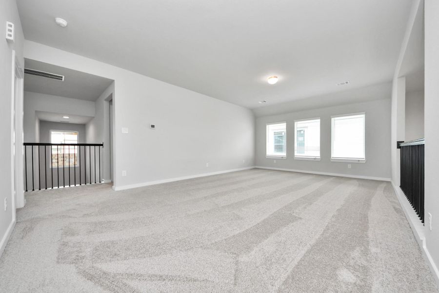 Ascend to relaxation in this fantastic game room! Ideal for both casual gatherings and adult gaming, it boasts plush carpet, lofty ceilings, custom paint, and ample windows for abundant natural light