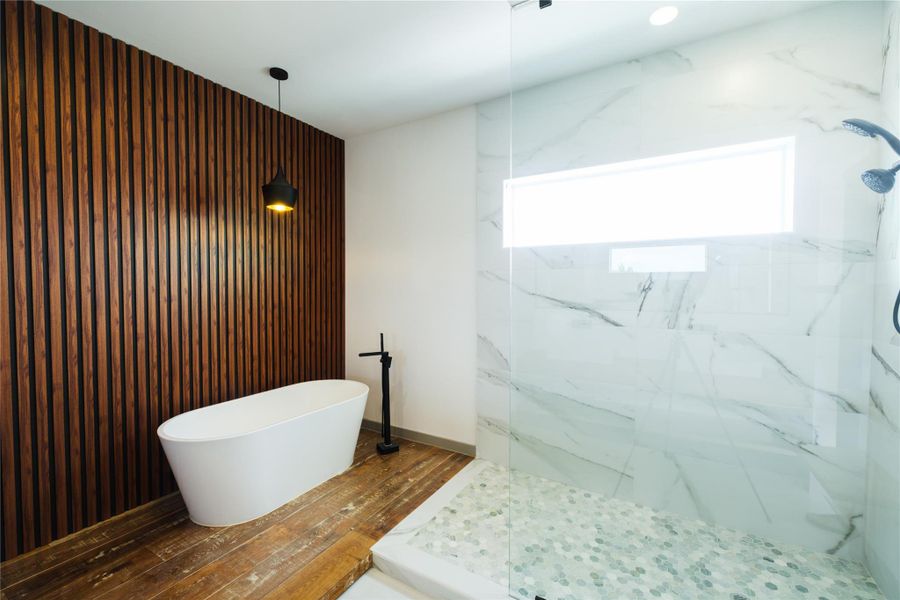Representative Primary Bath View  (Design selections and colors may vary): The spa-inspired primary bath includes a freestanding soaking tub on a floating platform, full-height slat wall backdrop, and an open-concept shower—blending luxury and tranquility.