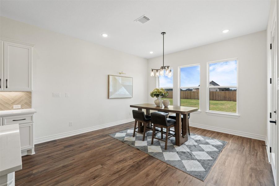 Dining space with dark wood finished floors, recessed lighting, and a chandelier Dining space with dark wood finished floors, recessed lighting, and a chandelier