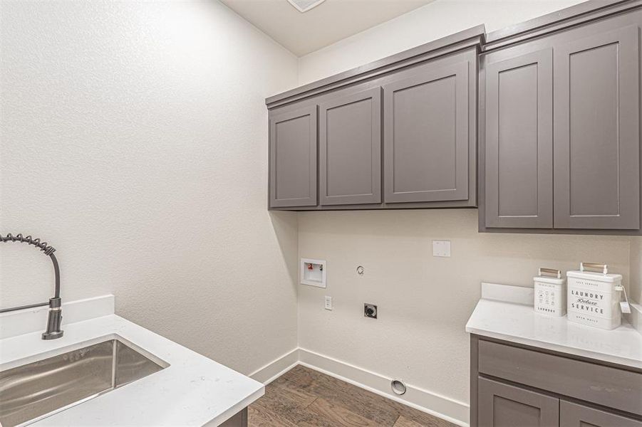 Laundry room featuring hookup for a gas dryer, dark wood-style floors, washer hookup, hookup for an electric dryer, and cabinet space