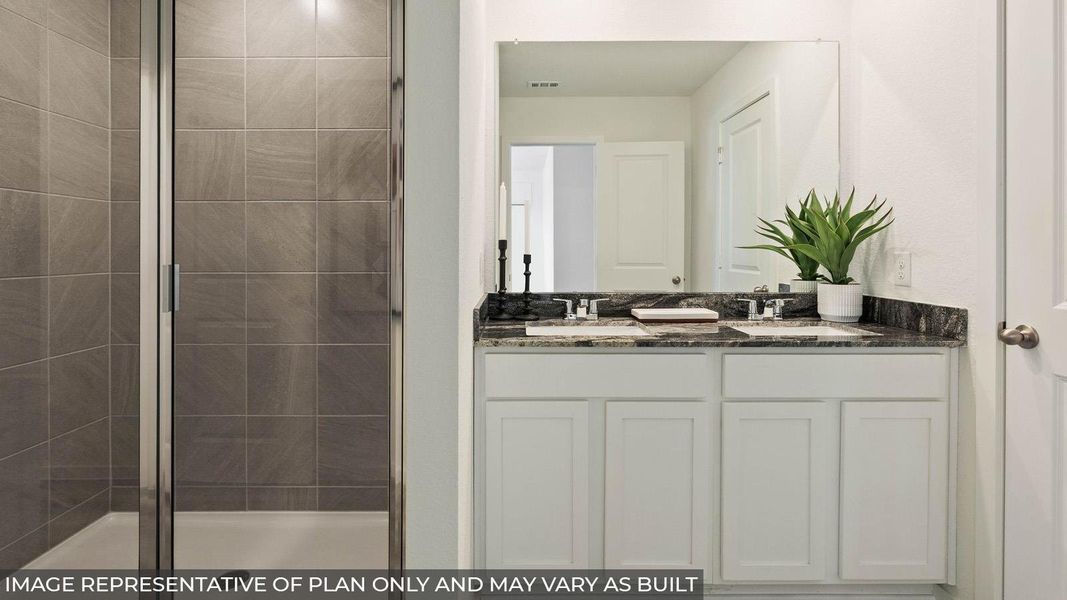 A well-appointed bathroom offers a dual vanity with granite counters and a tiled shower. A well-appointed bathroom offers a dual vanity with granite counters and a tiled shower.