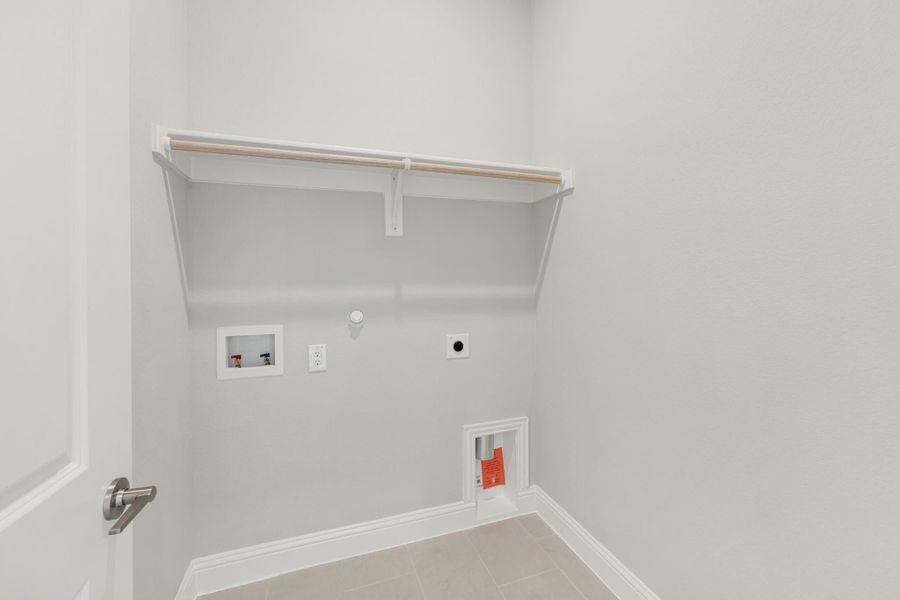 Laundry room with wall-mounted shelf, washer hookups, dryer vent, and tile floor
