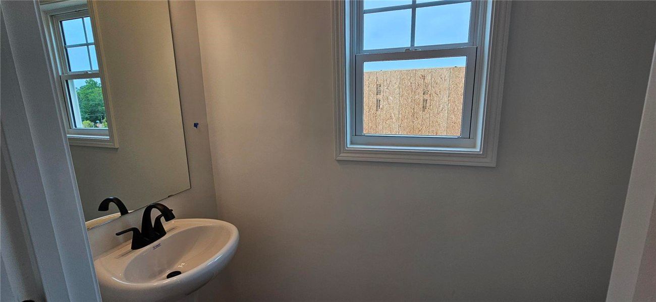 This bathroom showcases a sleek pedestal sink with This bathroom showcases a sleek pedestal sink with