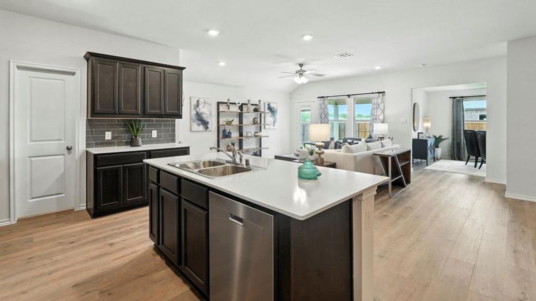 Kitchen with open floor plan, light countertops, dishwasher, backsplash, and a center island with sink Kitchen with open floor plan, light countertops, dishwasher, backsplash, and a center island with sink