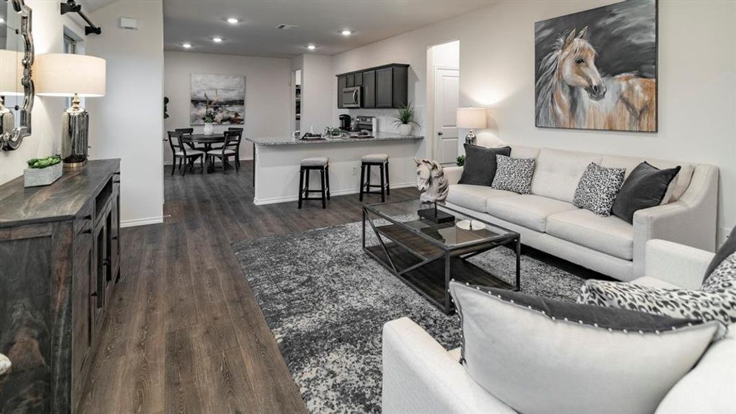 Living area with dark wood-type flooring and recessed lighting