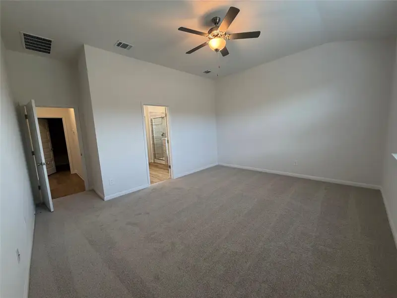 Unfurnished bedroom with light carpet, lofted ceiling, and ceiling fan