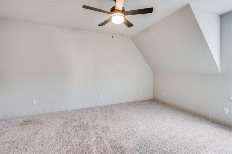 Bonus room with ceiling fan, carpet, and vaulted ceiling