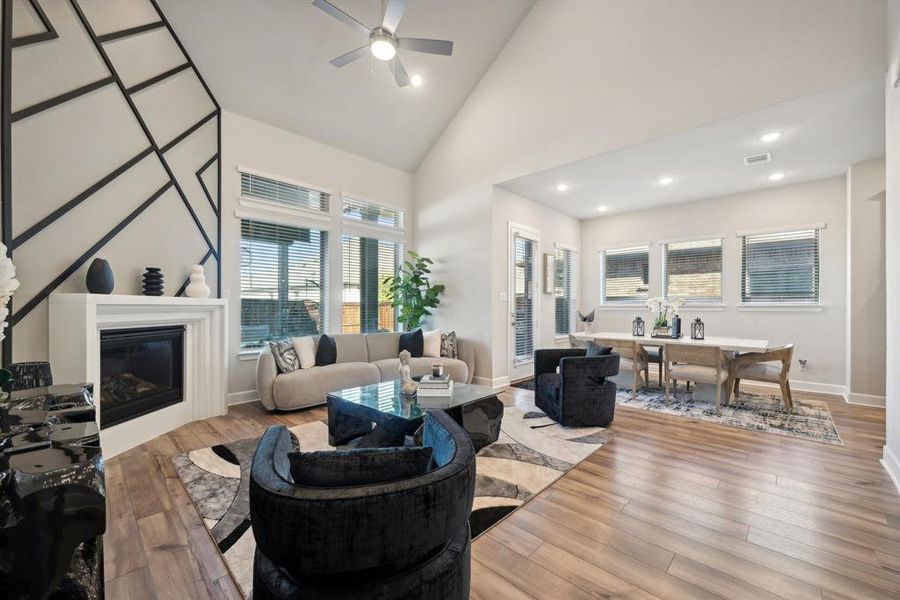 Living room featuring ceiling fan, light hardwood / wood-style flooring, and high vaulted ceiling