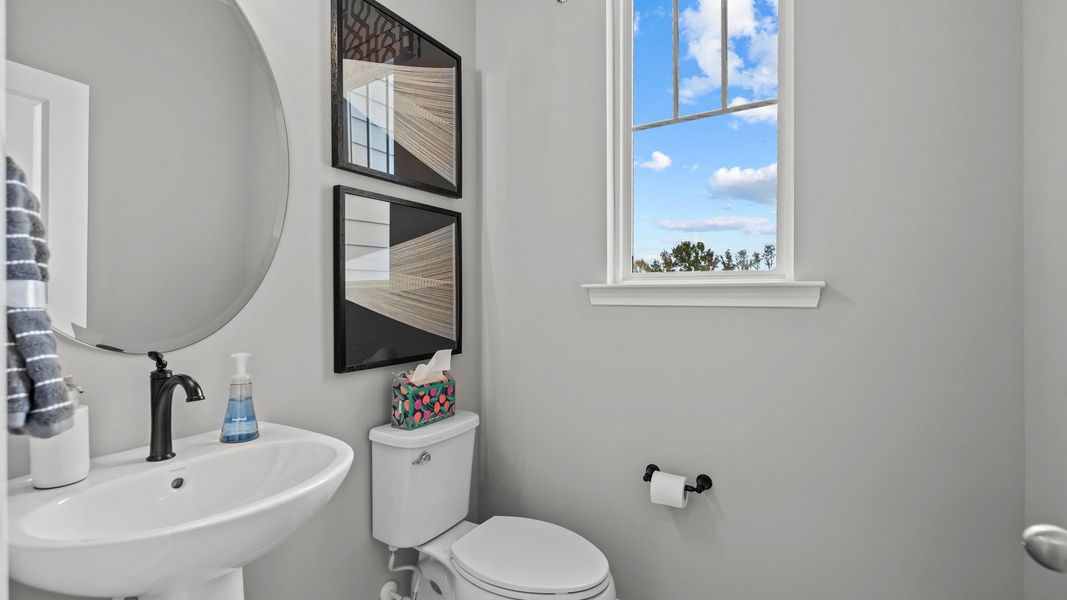 Convenient half bath with pedestal sink and window, in the Adaline Design by DRB Homes Charlotte, NC