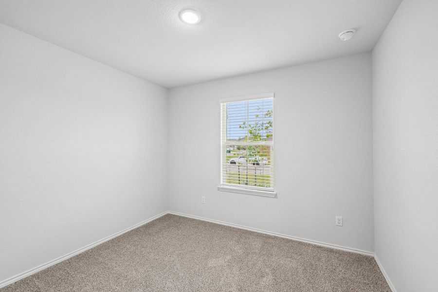 Room with light gray carpeting and white baseboards