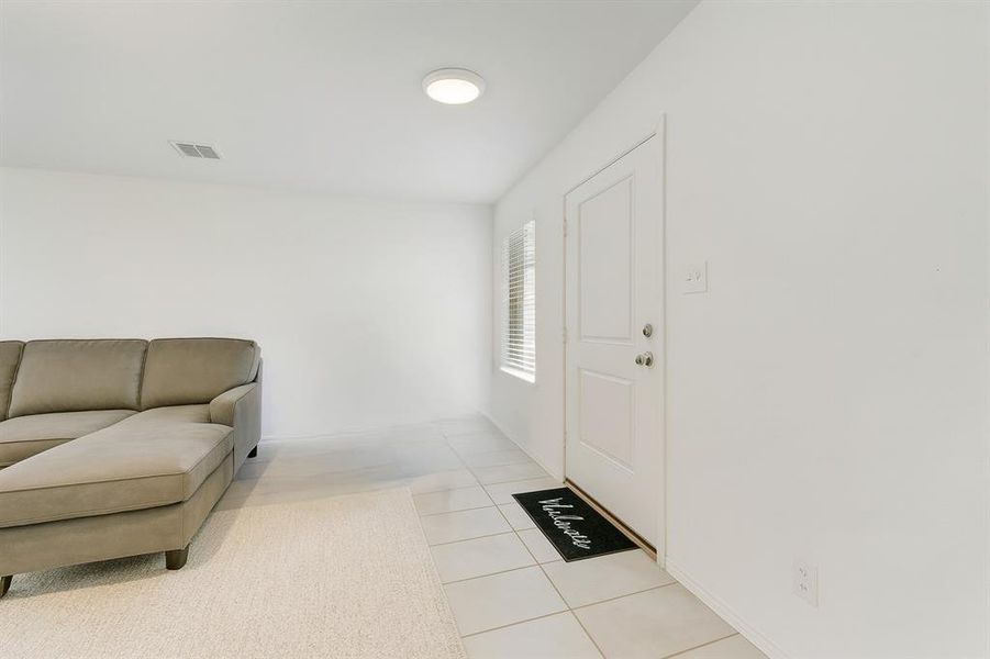 Entrance foyer with light tile patterned floors and baseboards Entrance foyer with light tile patterned floors and baseboards