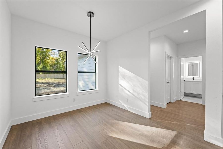 Unfurnished dining area featuring a notable chandelier and light hardwood / wood-style flooring