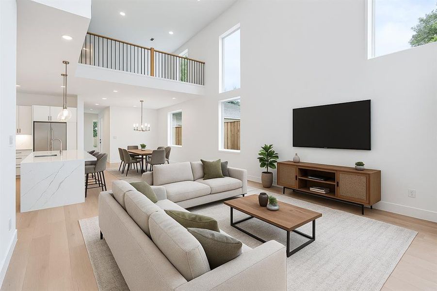 Living room featuring a high ceiling, light wood finished floors, baseboards, recessed lighting, and a chandelier
