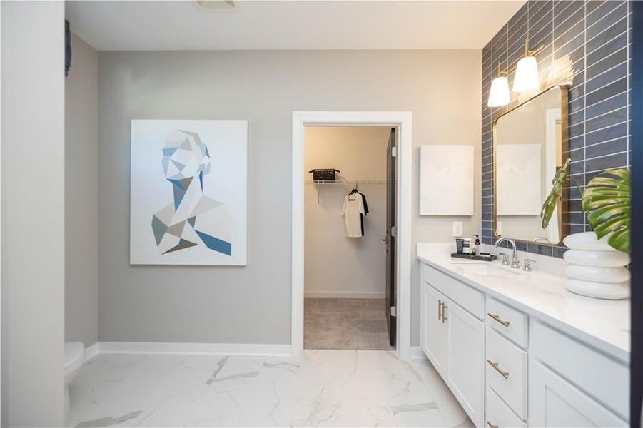 Bathroom with dual vanity, walk in shower with frameless shower door. Not actual home. Photos of Model Home.