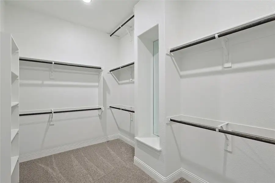 Walk in closet featuring light colored carpet Walk in closet featuring light colored carpet