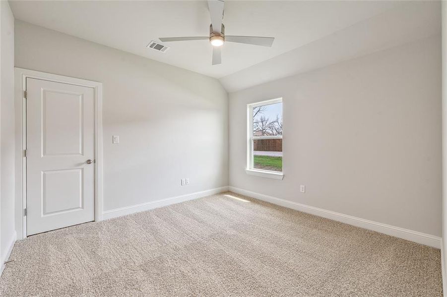 Carpeted spare room with lofted ceiling and ceiling fan