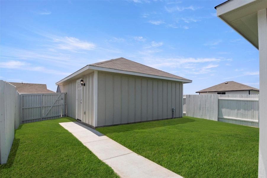 Fenced backyard with an outdoor structure Fenced backyard with an outdoor structure