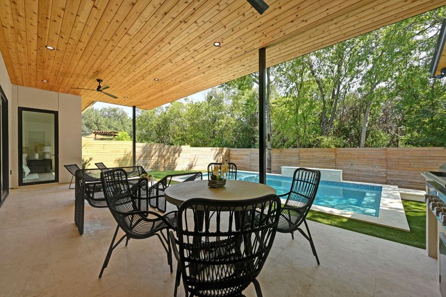 Fenced backyard featuring outdoor dining area, ceiling fan, and a patio area