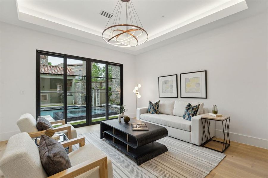 Office or flex room with white oak flooring, sliding iron & glass doors leading to courtyard, Tray ceiling with lighting and designer lighting Office or flex room with white oak flooring, sliding iron & glass doors leading to courtyard, Tray ceiling with lighting and designer lighting