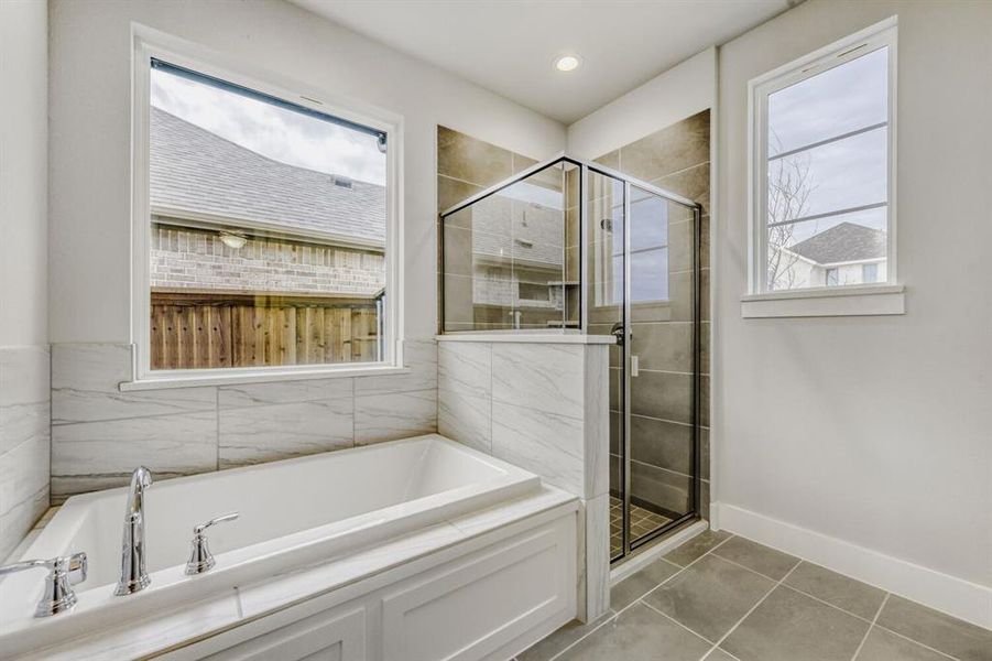 Bathroom featuring a stall shower, a garden tub, light tile patterned floors, recessed lighting, and plenty of natural light