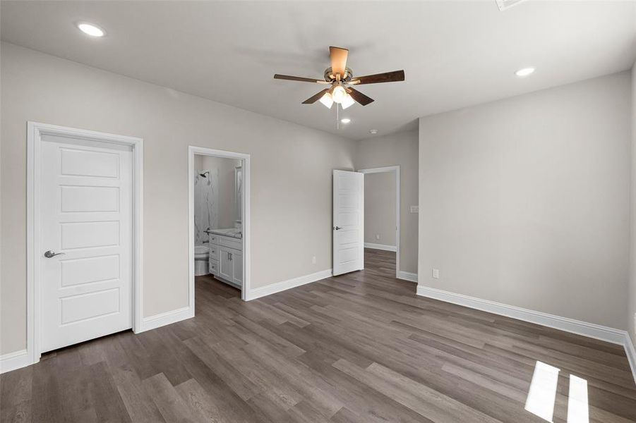 Bedroom with dark wood-type flooring, ceiling fan, and a healthy amount of sunlight