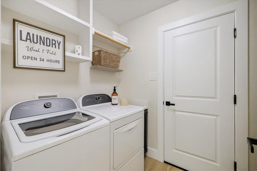 Laundry room with washer and dryer and light wood finished floors