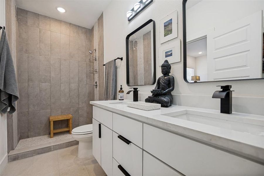 Bathroom featuring a dual vanity with integrated sinks, matte black faucets, and rectangular mirrors Bathroom featuring a dual vanity with integrated sinks, matte black faucets, and rectangular mirrors
