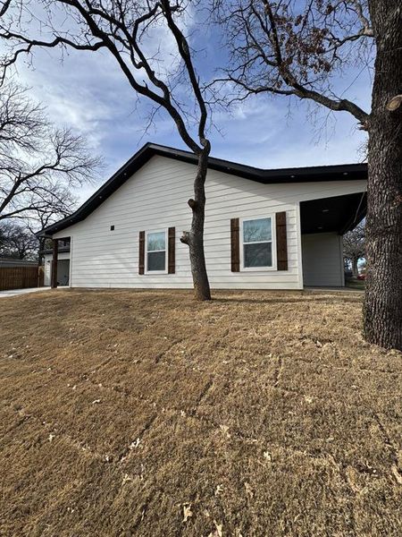 Side of property featuring a lawn