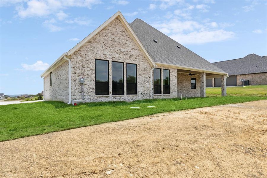 Rear view of property with a yard and ceiling fan