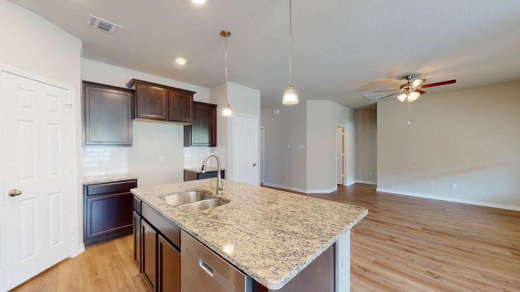 Kitchen featuring light wood-style flooring, dishwasher, a kitchen island with sink, and ceiling fan