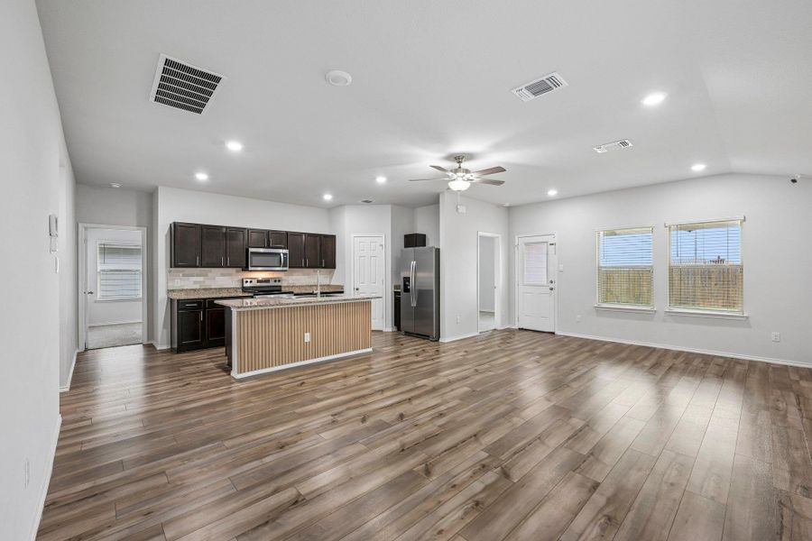 Open-concept living area featuring wood-finish flooring, recessed lighting, and a ceiling fan