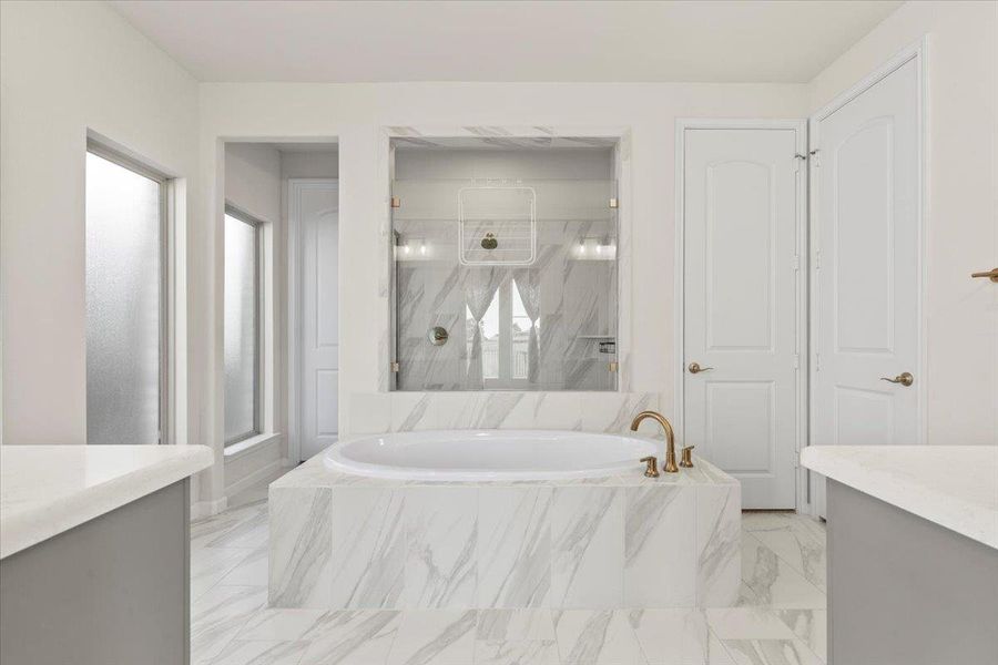 Full bath featuring vanity, a marble finish shower, a bath, and light marble finish floors Full bath featuring vanity, a marble finish shower, a bath, and light marble finish floors