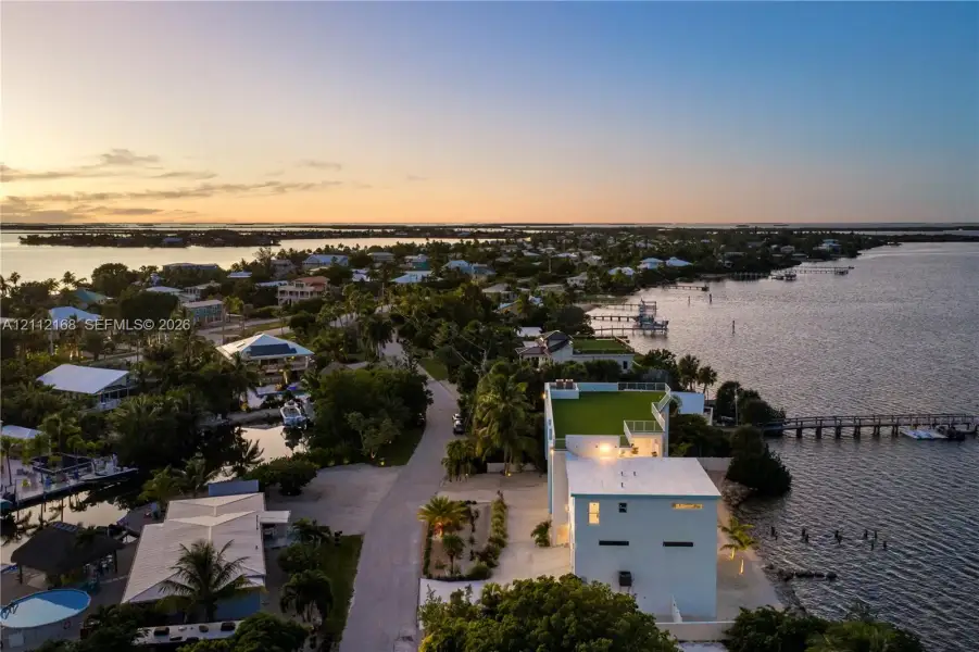 Waterfront property featuring a rooftop deck, private dock, multi-level exterior, and coastal location Waterfront property featuring a rooftop deck, private dock, multi-level exterior, and coastal location