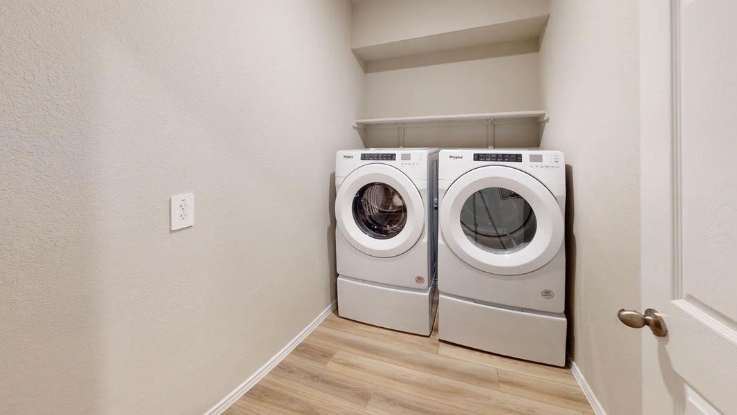 Functional laundry space featuring modern appliances and practical shelving. Functional laundry space featuring modern appliances and practical shelving.