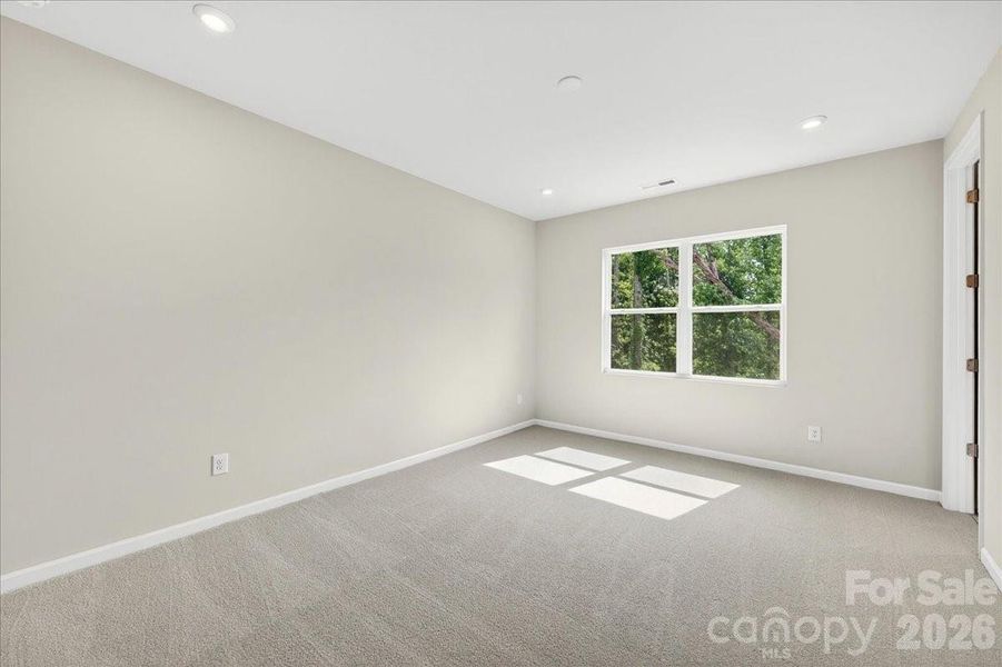 Primary bedroom with tree-lined views Primary bedroom with tree-lined views
