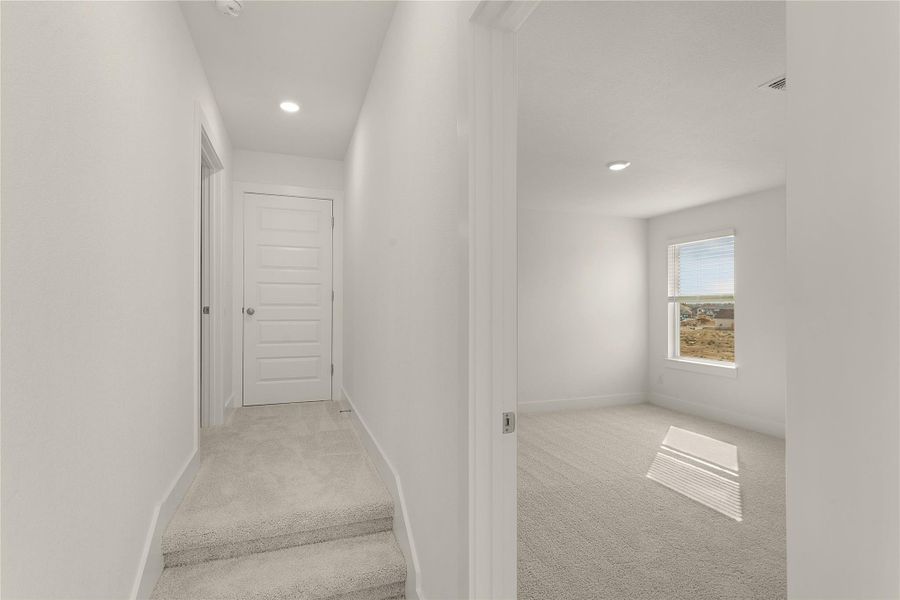 Corridor with carpet floors and recessed lighting