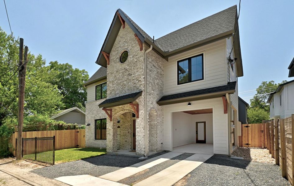 A striking modern facade combines brick and siding, featuring an arched entry and integrated garage. A striking modern facade combines brick and siding, featuring an arched entry and integrated garage.