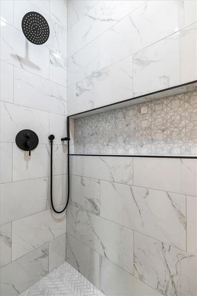 Shower enclosure featuring matte black fixtures, a rainfall showerhead, and a handheld shower