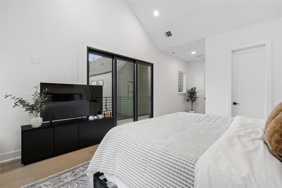 Serene and beautifully scaled, the third-floor primary suite unfolds beneath a cathedral ceiling that elevates both light and volume. Wide-plank engineered oak floors ground the space, while solid-core doors and thoughtful separation lead to a resort-style bath and custom-shelved wardrobe. A hush of calm, engineered for restorative nights and unhurried mornings