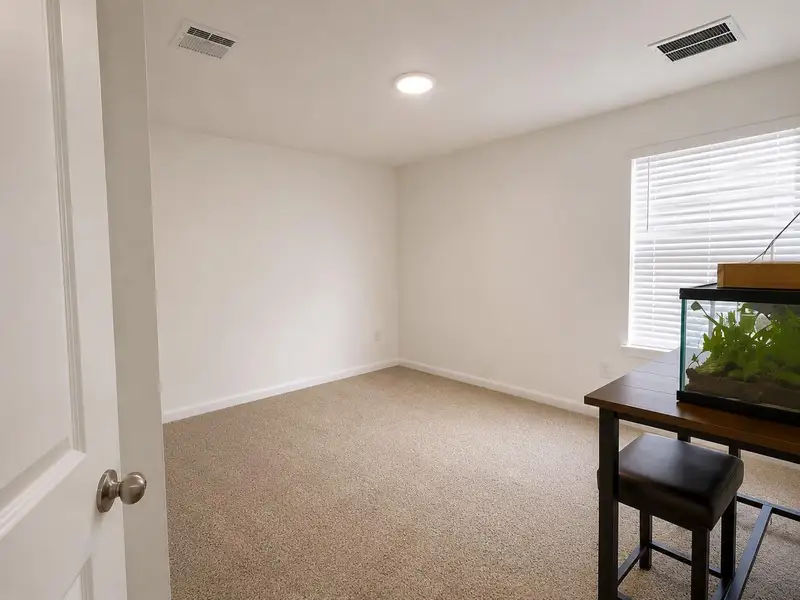 A well-lit room awaits your personal touch, featuring soft carpeting and a bright window. A well-lit room awaits your personal touch, featuring soft carpeting and a bright window.