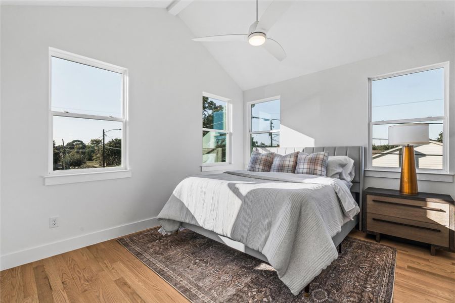 Another view of the primary suite highlighting the vaulted ceilings, custom windows & modern ceiling fan that together create a bright, tranquil atmosphere. Another view of the primary suite highlighting the vaulted ceilings, custom windows & modern ceiling fan that together create a bright, tranquil atmosphere.