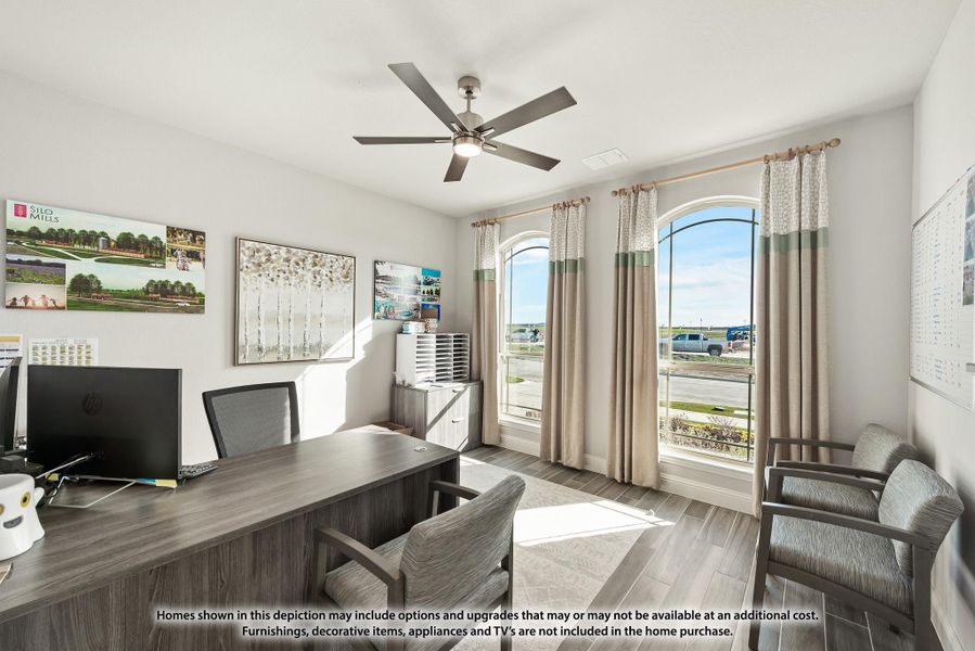 Home office with wood desk, ceiling fan, arched windows, and hardwood floors Home office with wood desk, ceiling fan, arched windows, and hardwood floors